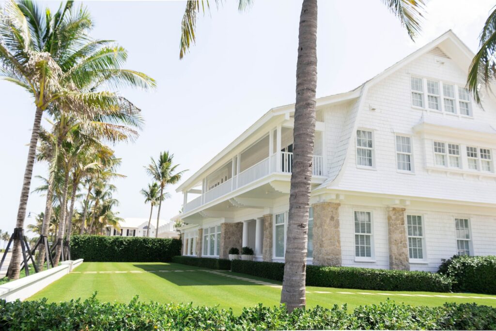 white wooden house near palm trees